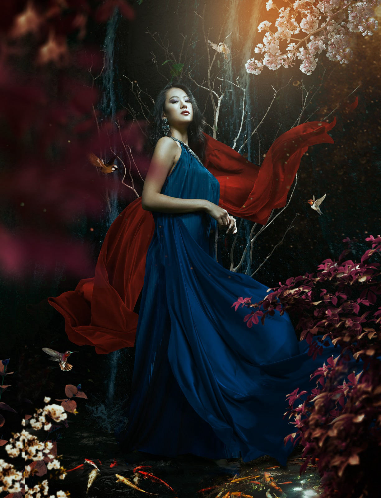 Fine art photography of a cinese model wearing a blue tunic surrounded by flowers and hummingbirds in nature